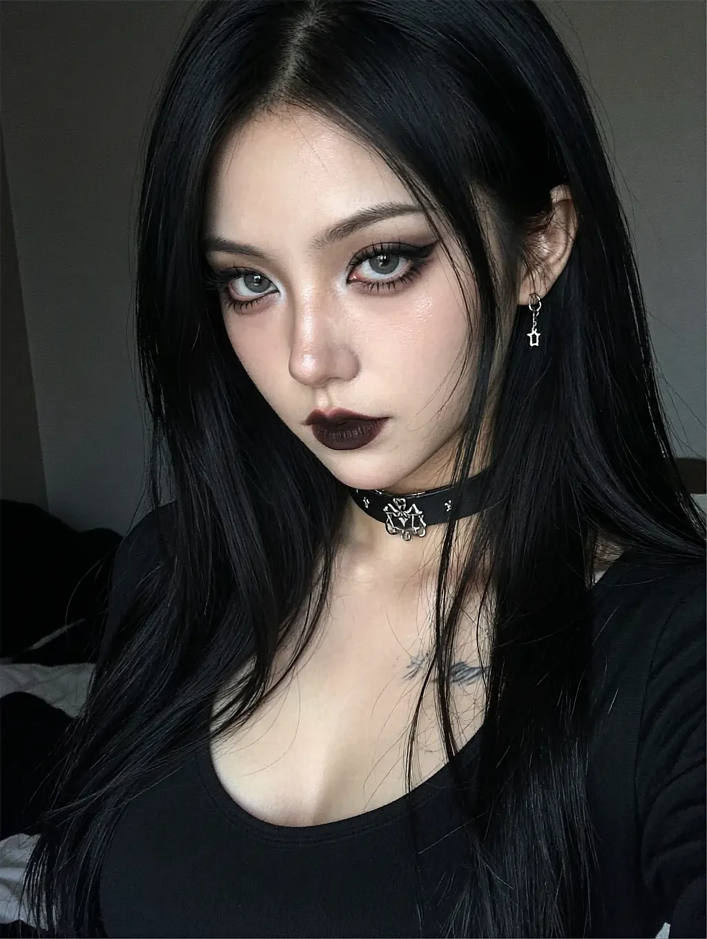 Astrid, a fictional AI character, with black lipstick and a studded choker in a dim room